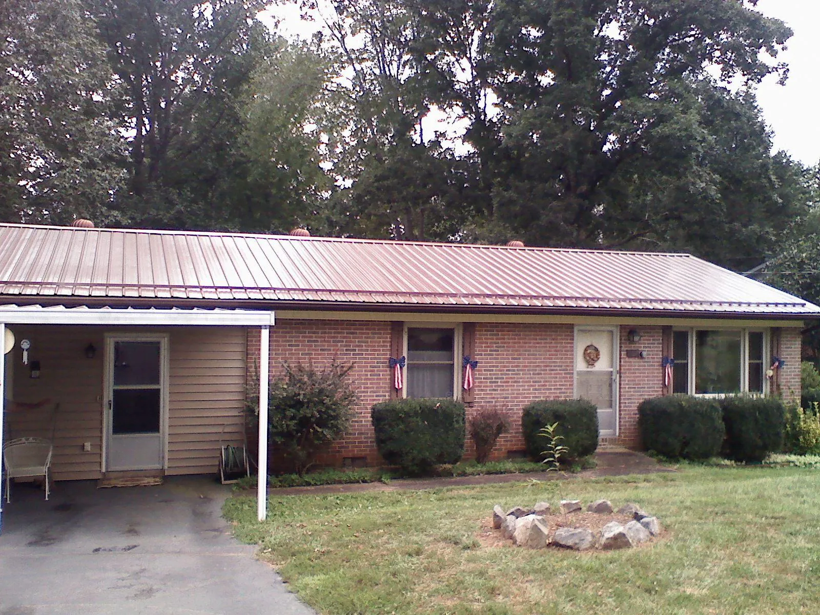 Bronze metal roof and carport on a brick ranch home — Roof Repair work by our crew in Jacksonville